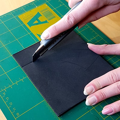 cuttermesser schneidet durch schwarzen foam